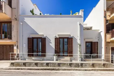 a bedroom with a bed and a desk with a chair at Casa Azzurra Rooms e apartment in Terrasini