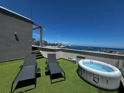 a patio with a hot tub on the roof of a house at Marina Rooftop Exclusive View in Palermo