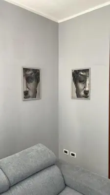 a living room with a couch and two pictures on the wall at Fun House in Trabia