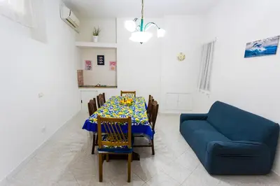 a dining room with a table and a blue couch at Pegaso 15 Home in Palermo