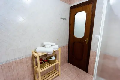a bathroom with white towels and a wooden door at Pegaso 15 Home in Palermo