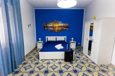 a blue bedroom with a bed and a blue wall at Pegaso 15 Home in Palermo