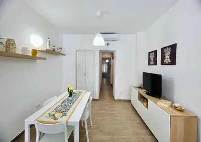 a living room with a dining table and a tv at Domus Livi in Cinisi