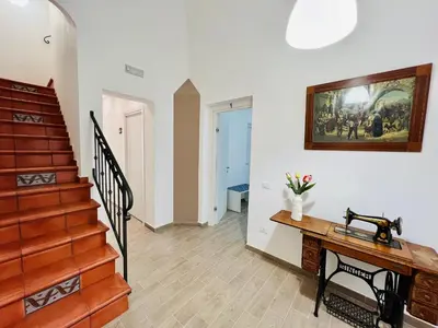 a room with a staircase and a table with flowers at Domus Livi in Cinisi