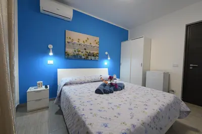 a blue bedroom with a bed with two stuffed animals on it at AL Quadrifoglio in Terrasini