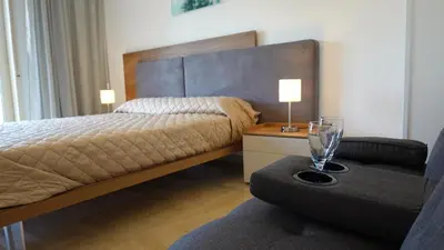 a bedroom with a bed and a couch and a chair at Appartamento Strasburgo in Palermo