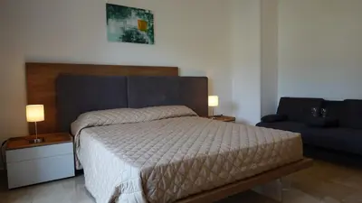 a bedroom with a large bed and a couch at Appartamento Strasburgo in Palermo