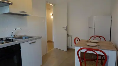 a kitchen with a sink and a table with chairs at Appartamento Strasburgo in Palermo