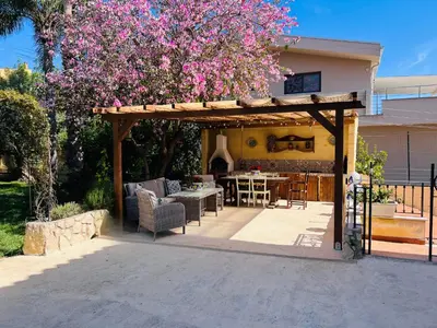 a pergola with a table and chairs in a backyard at Antico Casale Formica in Bagheria