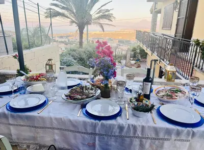 a table with plates of food and a bottle of wine at Antico Casale Formica in Bagheria