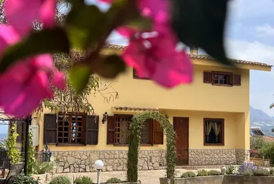 a house with pink flowers in front of it at Antico Casale Formica in Bagheria