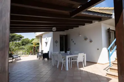 a dining area with a table and chairs on a patio at VillaThomas in Campofelice di Roccella