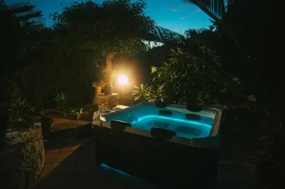 a hot tub in a garden at night at VillaThomas in Campofelice di Roccella