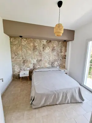 a bedroom with a large bed and a wall at Castellammare Riviera in Alcamo Marina