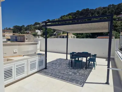 a patio with a table and chairs on a roof at Castellammare Riviera in Alcamo Marina