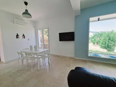 a dining room with a table and a window at Castellammare Riviera in Alcamo Marina