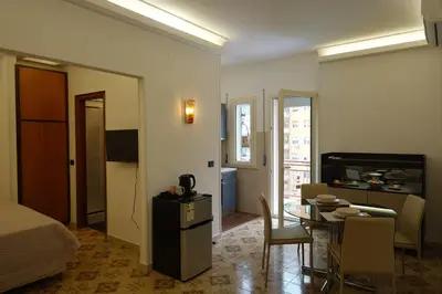 a room with a bed and a dining room with a table at AppartamentoBelgio in Palermo