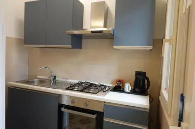 a kitchen with a sink and a stove top oven at AppartamentoBelgio in Palermo