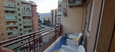 a balcony with white chairs and a view of a city at AppartamentoBelgio in Palermo