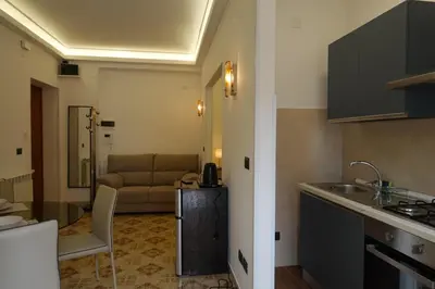 a kitchen and a living room with a couch at AppartamentoBelgio in Palermo