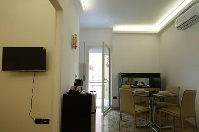 a dining room with a table and chairs and a television at AppartamentoBelgio in Palermo