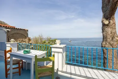a balcony with a table and chairs and the ocean at La Veranda Sul Mare in Santa Flavia