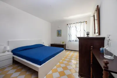 a bedroom with a bed with a blue comforter at La Veranda Sul Mare in Santa Flavia