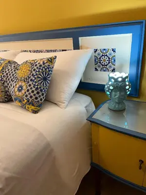 a bedroom with a bed with pillows and a table at Villa Triscele Holiday Home in Partinico