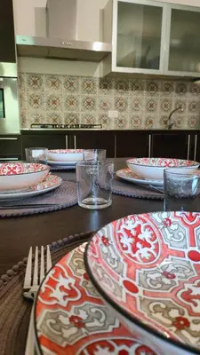 a table with red and white plates on top of it at Villa Triscele Holiday Home in Partinico