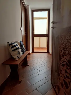 a hallway with a door and a bench and a window at B&B a casa di Peppe in Palermo