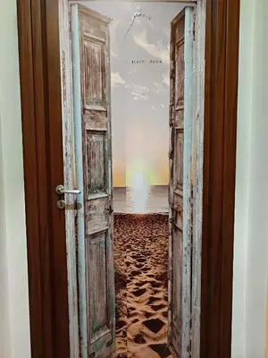 an open door to the beach with a view of the ocean at B&B a casa di Peppe in Palermo