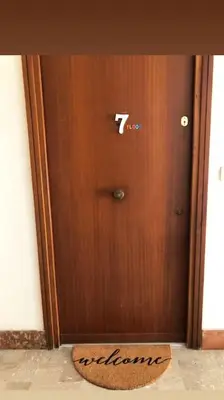 a wooden door with a sign in front of it at 7 floor in Palermo