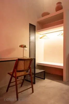 a room with a chair and a bed at Lofterì by DomuSicily in Palermo