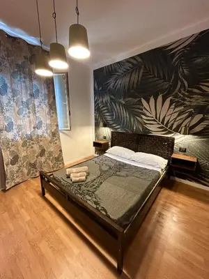 a bedroom with a large bed with a painting on the wall at Zagara in Palermo