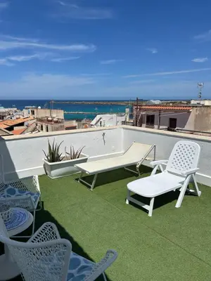 a patio with chairs and a table on a roof at Attico con vista mozzafiato a due passi dal mare in Terrasini