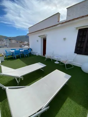 a group of tables and chairs on a building at Attico con vista mozzafiato a due passi dal mare in Terrasini