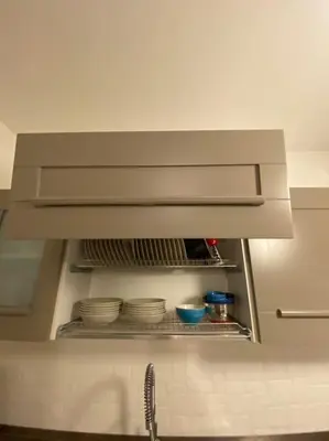 a kitchen with a hood over a sink with plates at Attico con vista mozzafiato a due passi dal mare in Terrasini