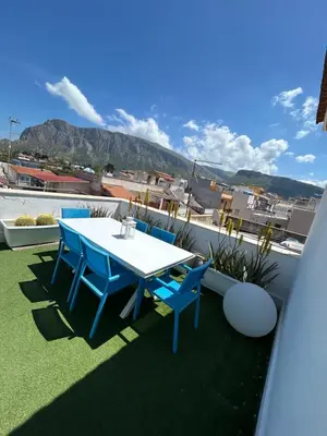 a table and chairs on a balcony with a view at Attico con vista mozzafiato a due passi dal mare in Terrasini