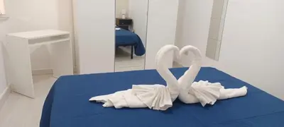 two white swans are sitting on a blue bed at Ballar'Home - Casa Sbriju' in Palermo