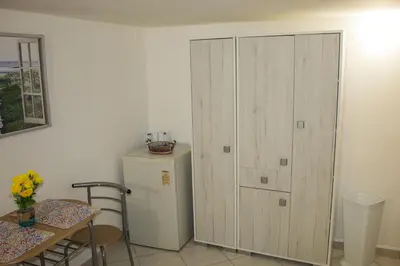 a room with a cabinet and a refrigerator and a table at politeama guest house il rifugio Palermo in Palermo
