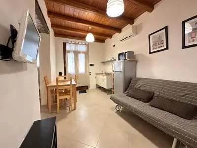 a living room with a bed and a table and a kitchen at Marcantonio Suite in Castellammare del Golfo