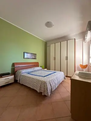 a bedroom with a bed and green walls at Casa Letizia in Alcamo