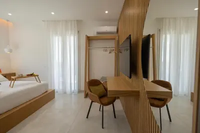 a bedroom with a bed and a desk and chairs at BellaVista in Cinisi