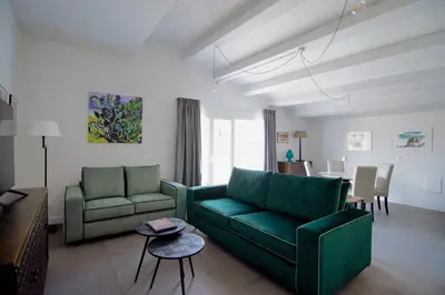 a living room with two green couches and a table at Maciuni Apartment in Palermo