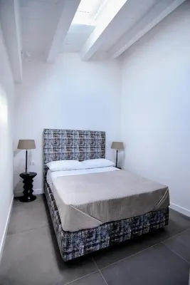 a bedroom with a bed in a white room at Maciuni Apartment in Palermo