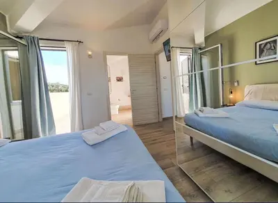 two beds in a room with a mirror at Villa Charme & Relax in Campofelice di Roccella