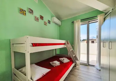 a bunk bed in a room with green walls at Villa Charme & Relax in Campofelice di Roccella