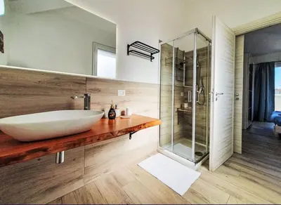 a bathroom with a sink and a glass shower at Villa Charme & Relax in Campofelice di Roccella