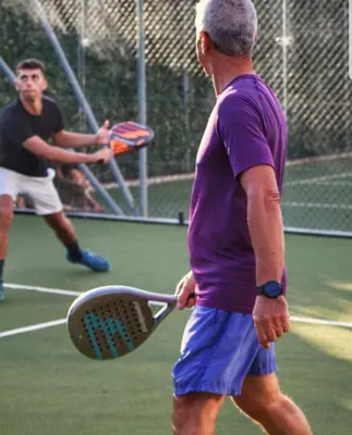 a man holding a tennis racket on a tennis court at Villa Charme & Relax in Campofelice di Roccella