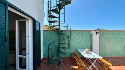 a spiral staircase on the side of a green wall at La Terrazza sul Mare in Palermo